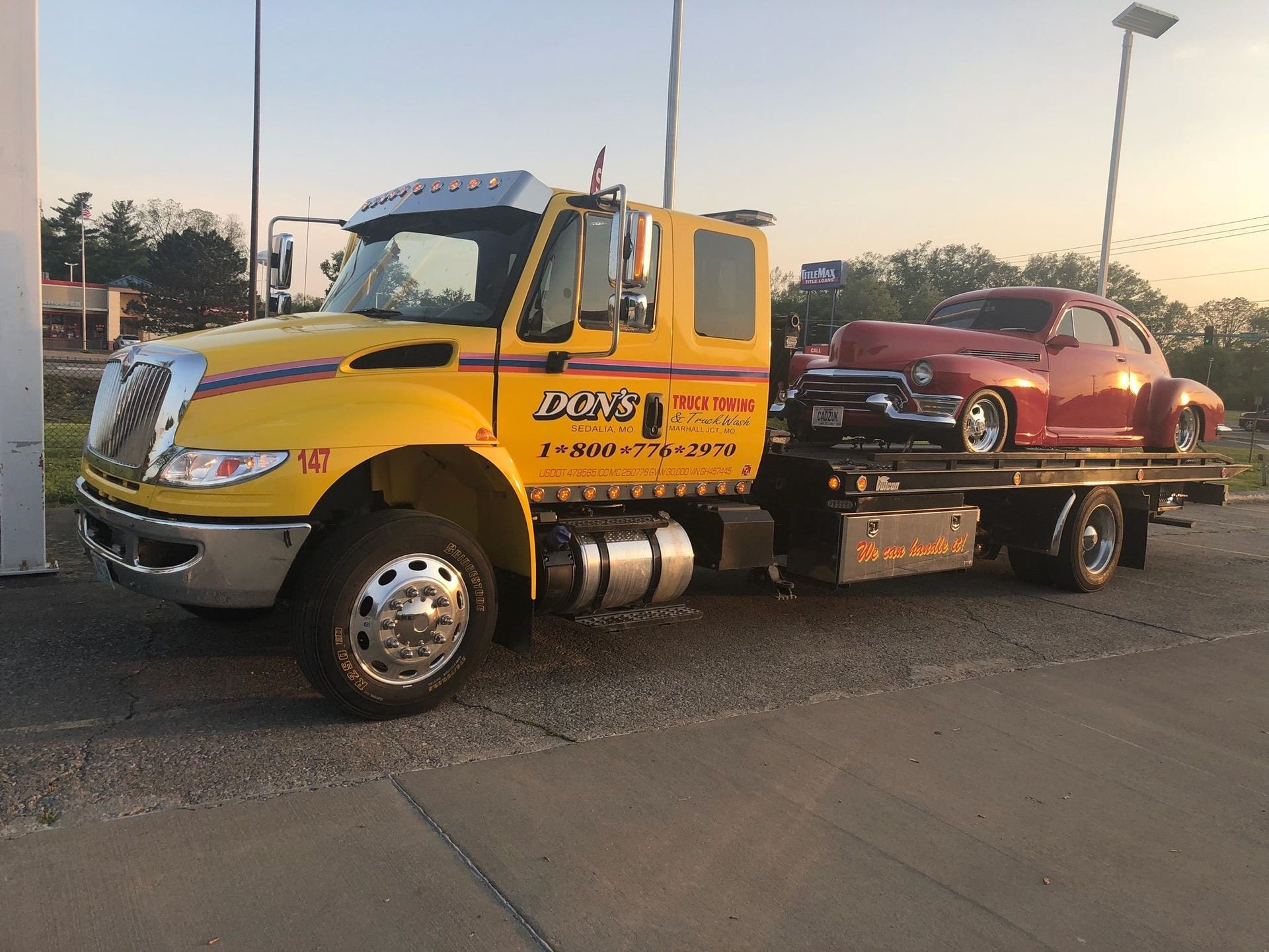 Don’s yellow flatbed carrying a red classic passenger car